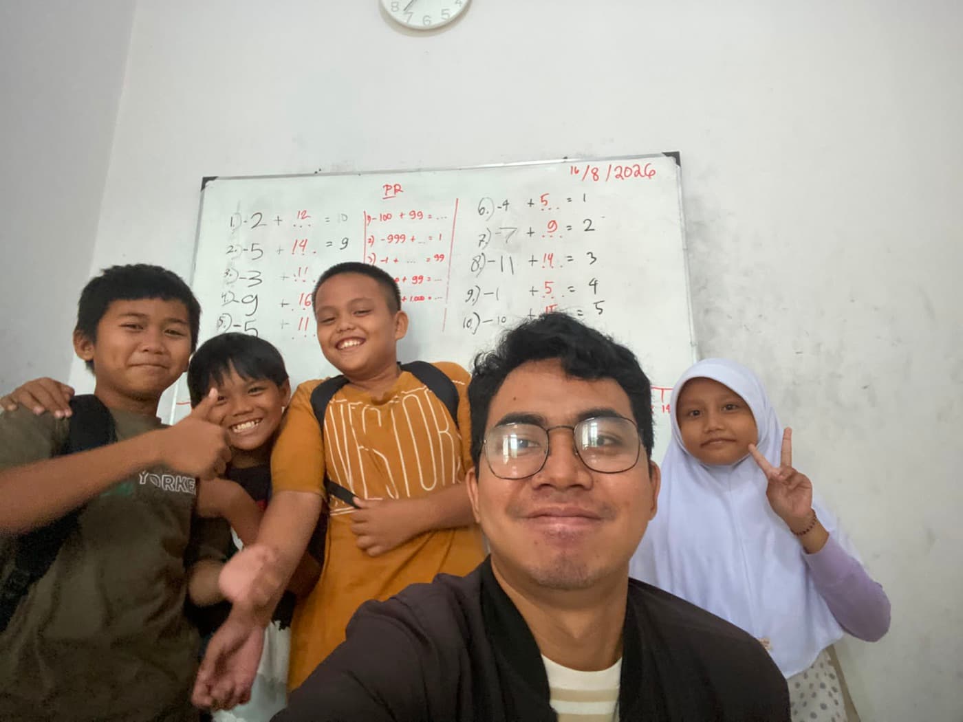Tito berswafoto bersama murid-murid bimbel di depan papan tulis